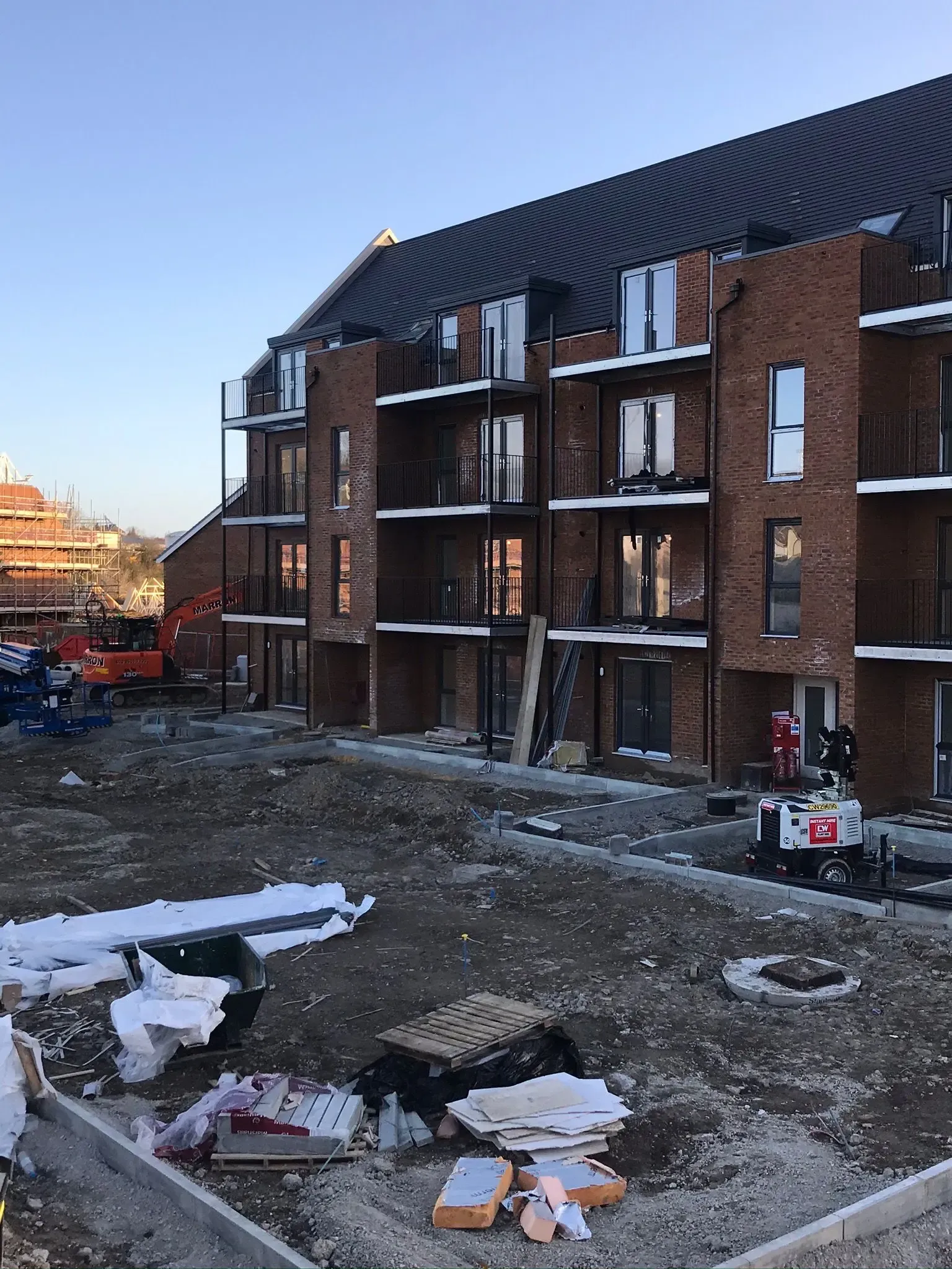 Ongoing commercial groundworks, site preparation, and concrete footings at a new building development construction site.