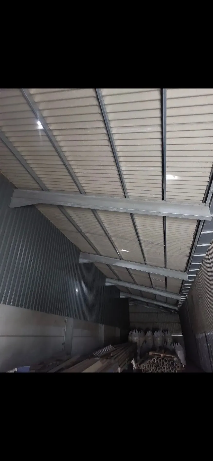 Interior of a steel-framed agricultural building with metal cladding and concrete walls